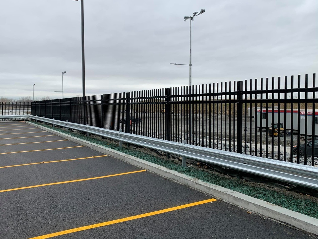 Machinerie lourde pour l'installation d'un périmètre de sécurité de clôture industrielle sur chantier